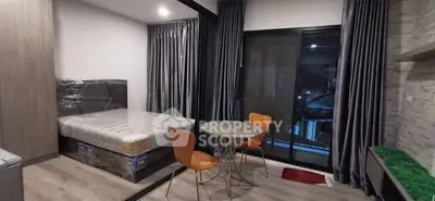 Modern studio apartment with cozy dining area and large windows offering a city view.