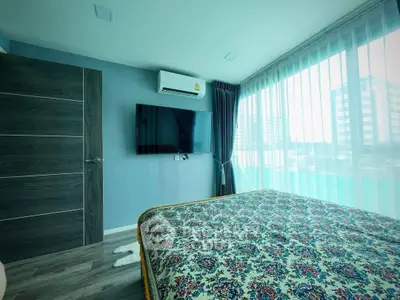 Modern bedroom with large windows and city view, featuring a wall-mounted TV and air conditioning.