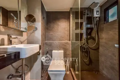 Modern bathroom with sleek design, featuring a glass shower and contemporary fixtures.