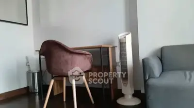 Cozy study nook with modern chair and fan in a stylish apartment.
