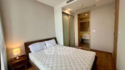 Modern bedroom with wooden flooring and ensuite bathroom in a stylish apartment.