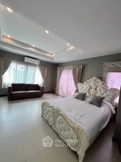 Luxurious bedroom with elegant bed and spacious layout, featuring large windows and stylish decor.