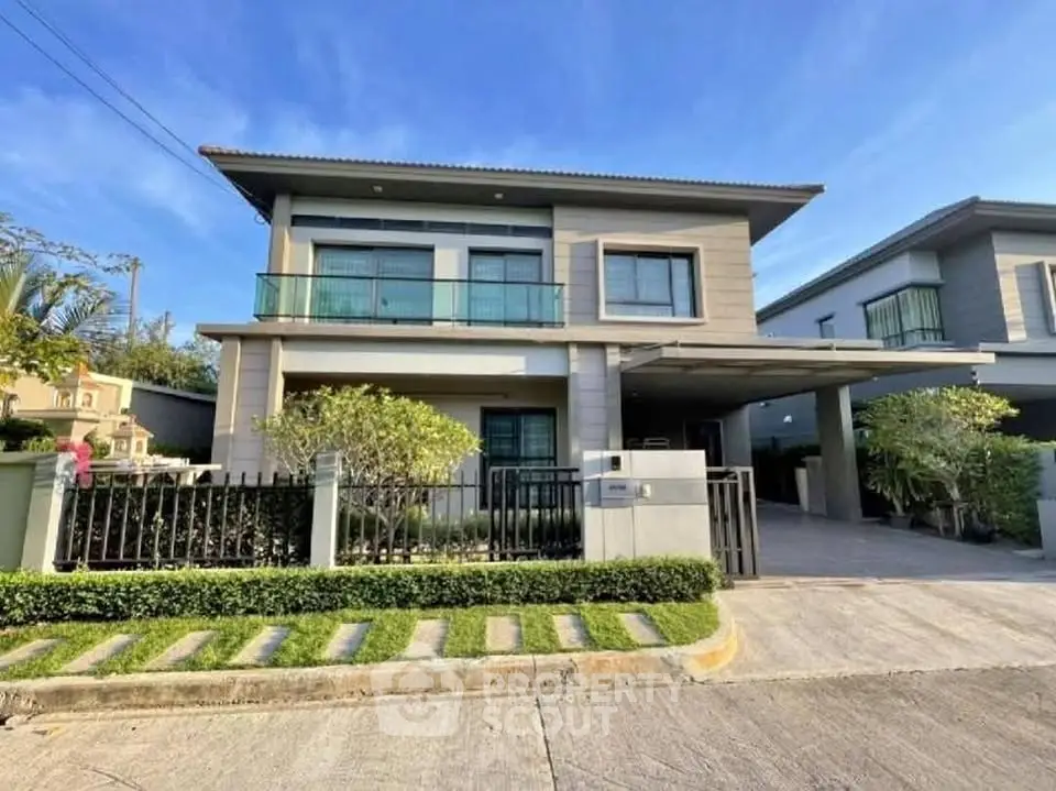 Modern two-story house with landscaped front yard and driveway in a suburban neighborhood.