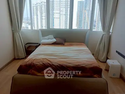 Spacious bedroom with city view, featuring a cozy bed and large windows for natural light.