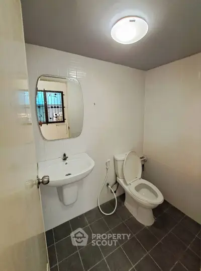 Modern bathroom with sleek white tiles and contemporary fixtures.