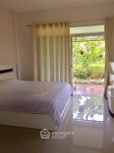 Bright bedroom with garden view and sliding glass doors opening to patio.
