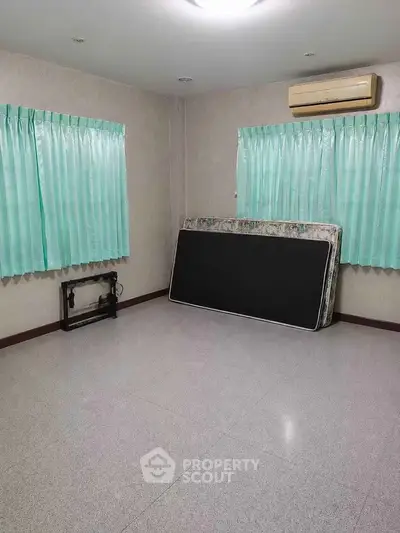 Spacious unfurnished room with air conditioning and large windows, ideal for customization.
