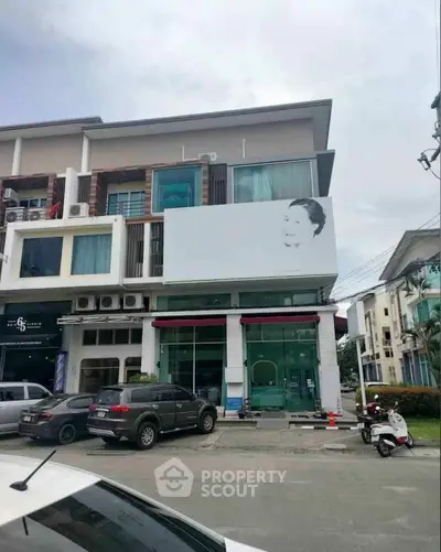 Modern commercial building with parking space and large signage area.
