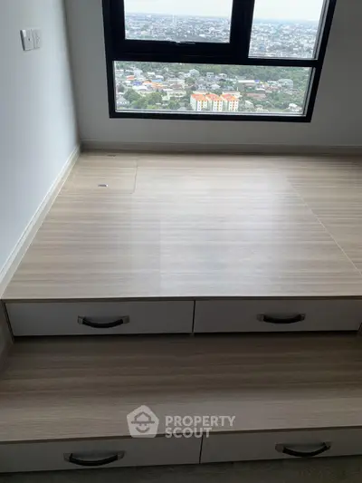 Modern apartment with built-in storage and stunning city view from large window.