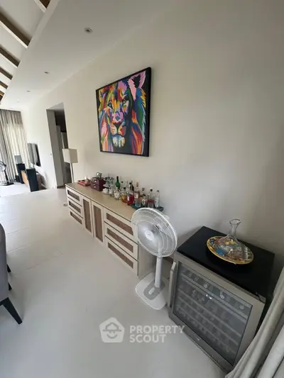 Stylish living room with modern decor and mini bar setup, perfect for entertaining guests.
