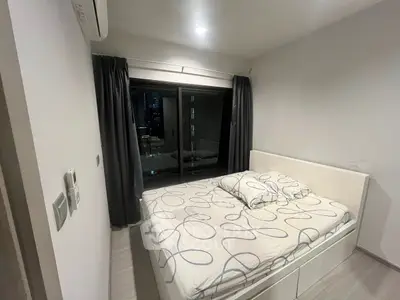 Modern bedroom with city view, featuring a cozy bed and sleek design, perfect for urban living.