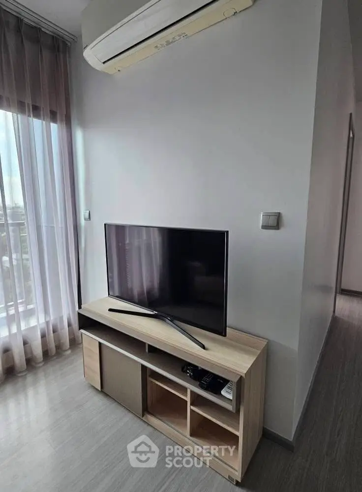 Modern living room with sleek TV setup and air conditioning, perfect for cozy entertainment.