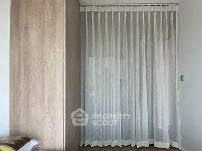 Modern bedroom with elegant sheer curtains and wooden wardrobe