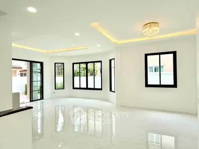 Spacious modern living room with large windows and elegant lighting in a luxury home.