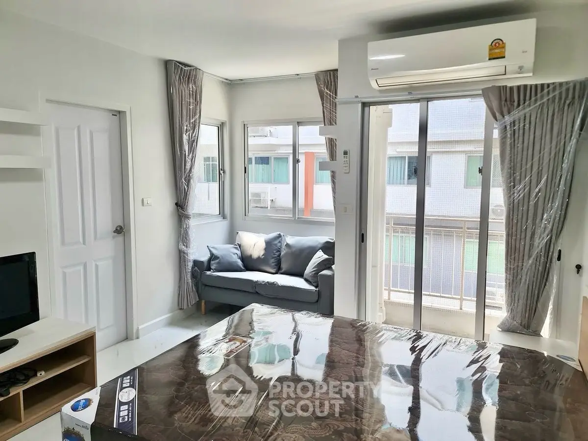Modern living room with balcony access and air conditioning in urban apartment