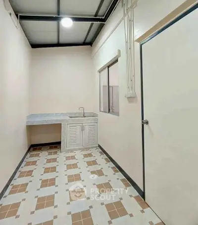 Minimalist kitchen with tiled floor and compact sink area