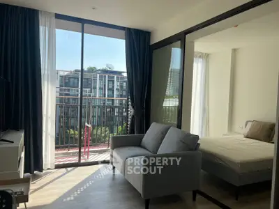 Modern apartment with balcony, featuring a cozy living area and bedroom, offering ample natural light.