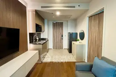 Modern apartment interior with sleek kitchen and cozy living area, featuring wood accents and contemporary design.