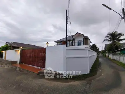 Charming two-story house with modern design and gated entrance in a serene neighborhood.