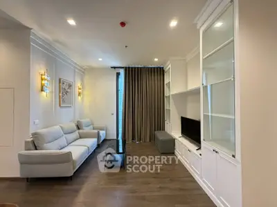 Elegant living room with modern furniture and built-in shelving, featuring a cozy ambiance and stylish decor.