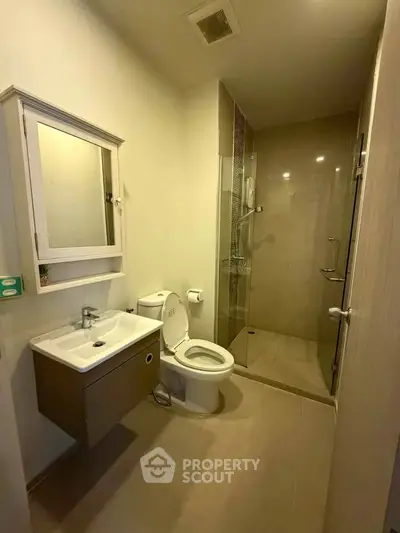 Modern bathroom with sleek shower and stylish vanity in contemporary apartment.