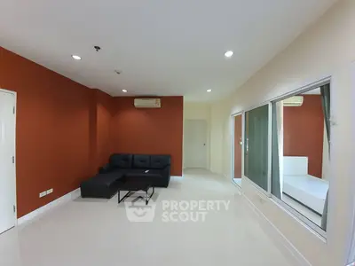 Spacious living room with modern sofa and large windows in a stylish apartment.