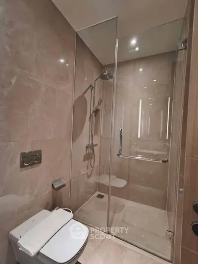 Luxurious modern bathroom with sleek glass shower and elegant marble tiles