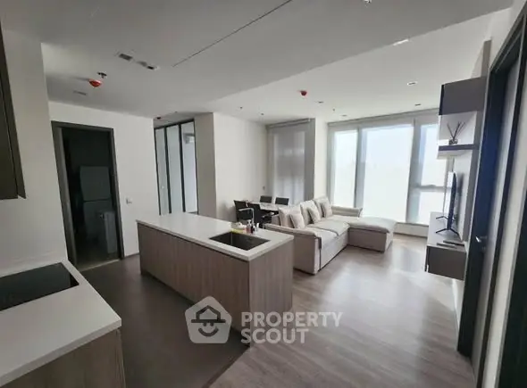 Modern open-plan living room with kitchen island and large windows