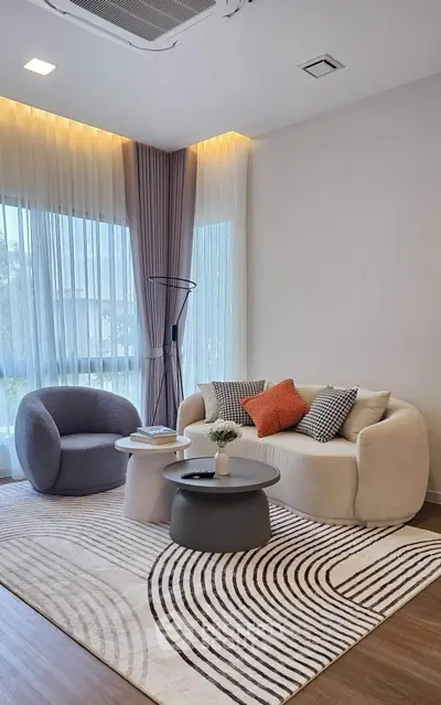 Stylish modern living room with cozy seating and elegant decor, featuring large windows and natural light.