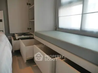Sleek modern kitchen with built-in gas stove and ample storage space, featuring pull-out drawers and frosted glass window for natural light.