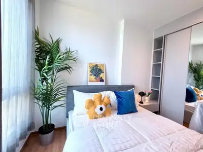 Bright and cozy bedroom with modern decor and large window for natural light.