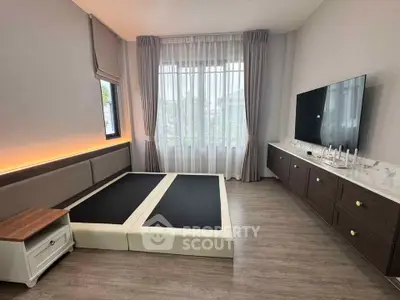 Spacious bedroom with modern decor and large window for natural light