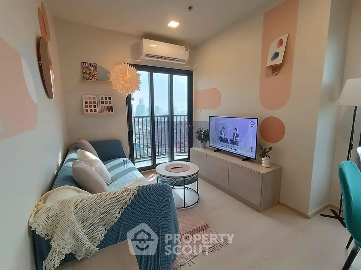 Modern living room with balcony view, stylish decor, and cozy seating area in a high-rise apartment.