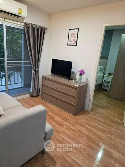 Cozy living room with modern decor and balcony access in stylish apartment.