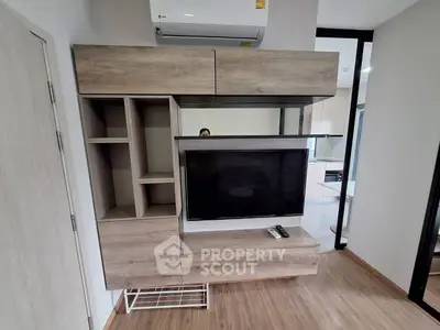 Modern living room with sleek wooden TV cabinet and air conditioning unit.