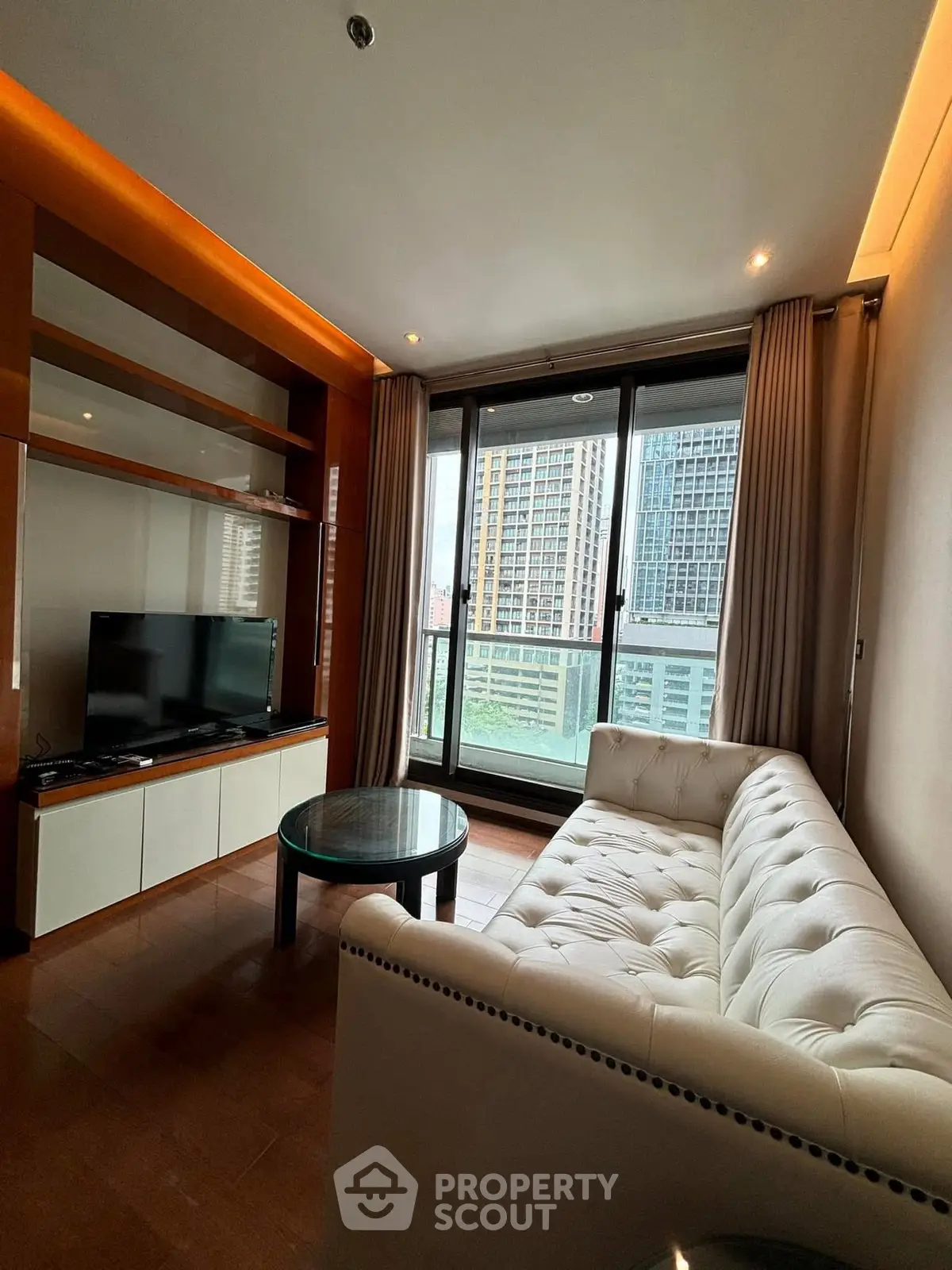 Modern living room with elegant sofa and city view balcony in luxury apartment.
