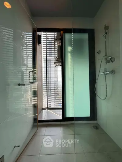 Modern bathroom with glass shower and city view, featuring sleek fixtures and contemporary design.