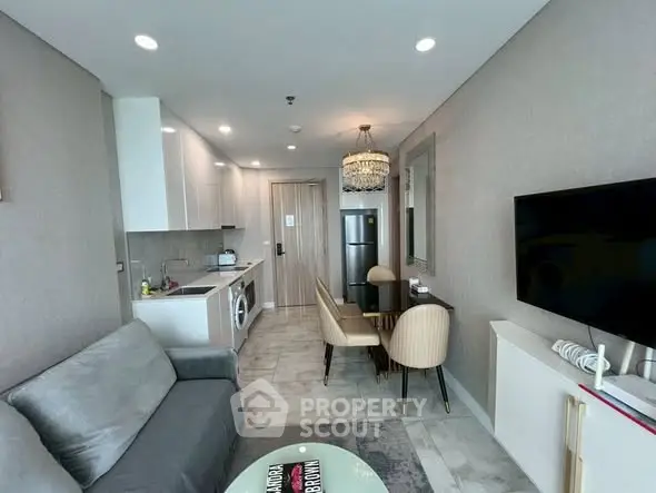 Modern living room with open kitchen, elegant dining area, and cozy seating in a stylish apartment.