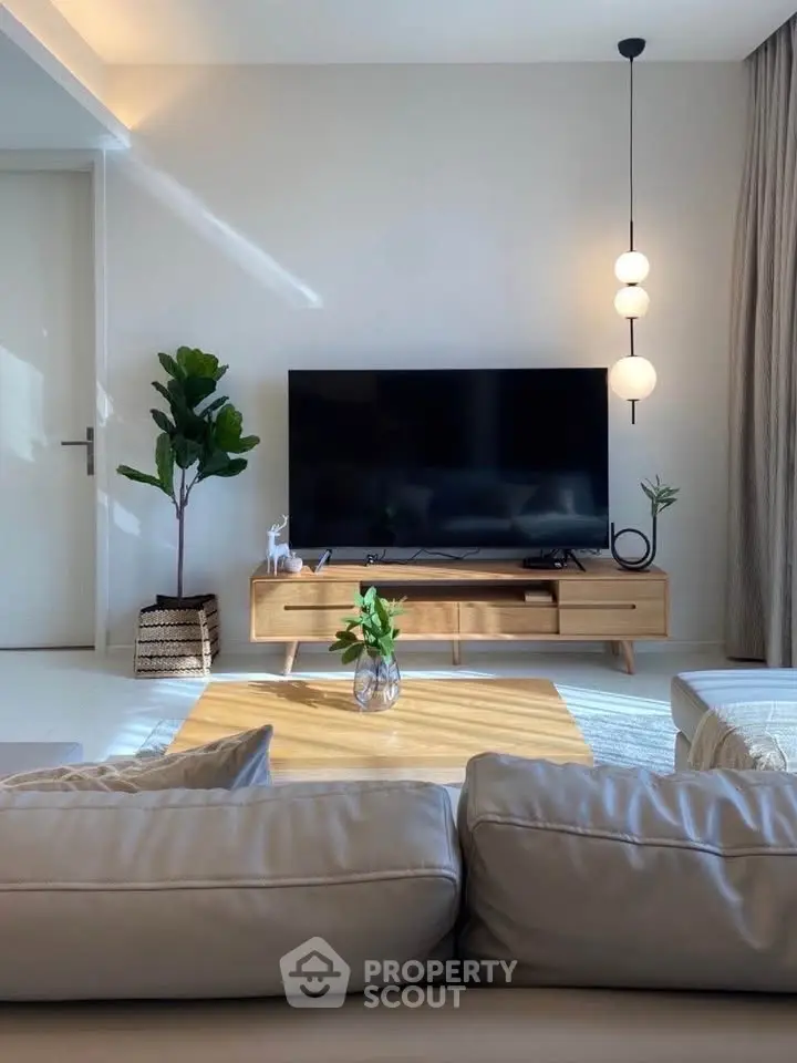 Modern living room with sleek TV stand, stylish lighting, and cozy seating area.