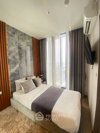 Modern bedroom with stylish decor and large window offering city view