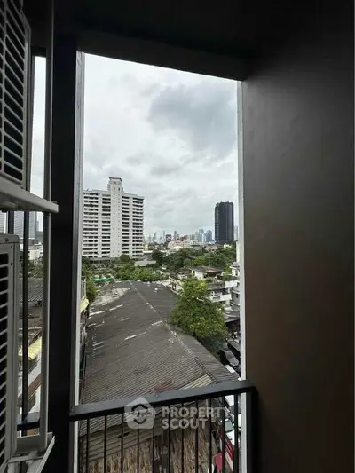 Urban balcony view with city skyline and residential buildings.