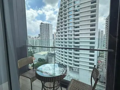 Stunning high-rise balcony with cityscape view and cozy seating area.
