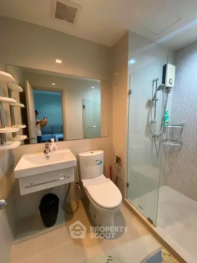 Modern bathroom with glass shower and sleek fixtures in a contemporary apartment.