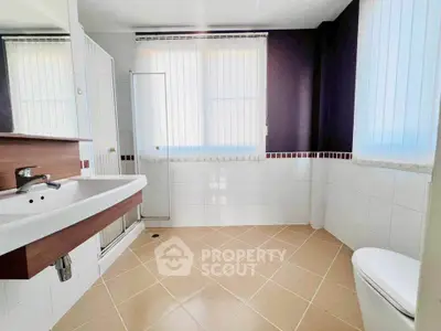 Spacious and bright bathroom with modern fixtures and large windows.