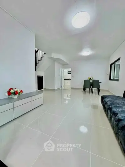 Spacious modern living room with sleek design and elegant dining area, perfect for contemporary living.