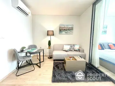 Modern studio apartment with sleek furniture and ample natural light, featuring a cozy living area and a comfortable bedroom space.