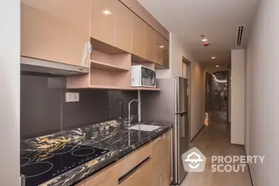 Modern kitchen with sleek marble countertops and built-in appliances in a stylish apartment.