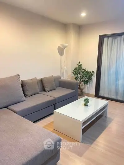 Modern living room with cozy gray sofa and sleek white coffee table, perfect for relaxation.