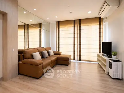 Spacious modern living room with brown leather sofa and large windows