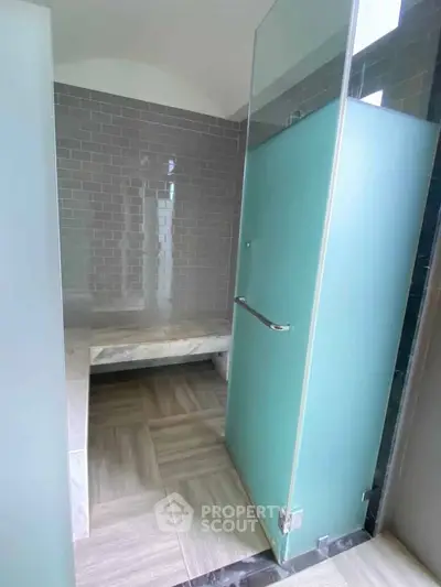 Modern bathroom with frosted glass door and sleek tile design
